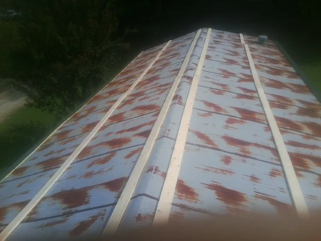 Rusted metal roof panels with new wood purlins before replacement — Storm Damage Roof Repair in Ireton by Roofing Brothers