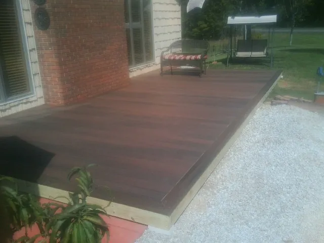 Freshly stained wood deck built against a brick home in Ireton