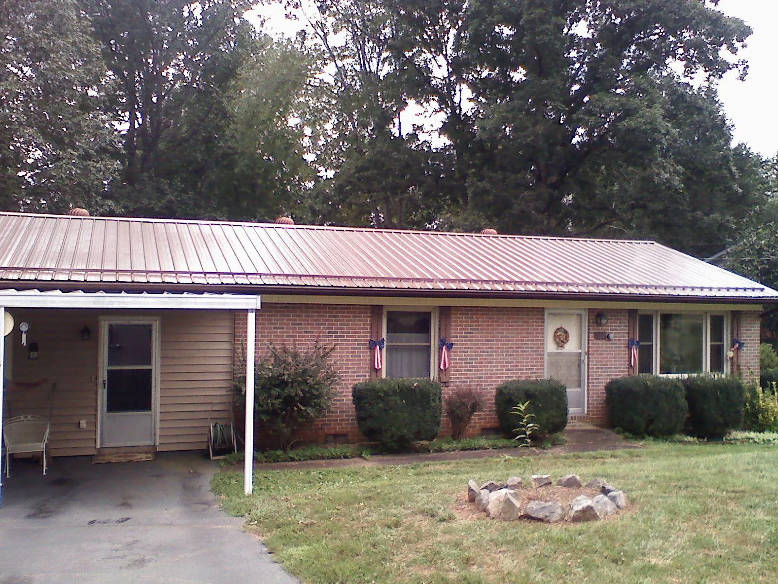 Bronze metal roof and carport on a brick ranch home — Roof Repair work by our crew in Ireton